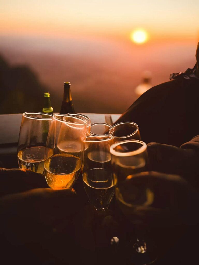 Group of people clinking champagne glasses at sunset, celebrating on a yacht in Mallorca