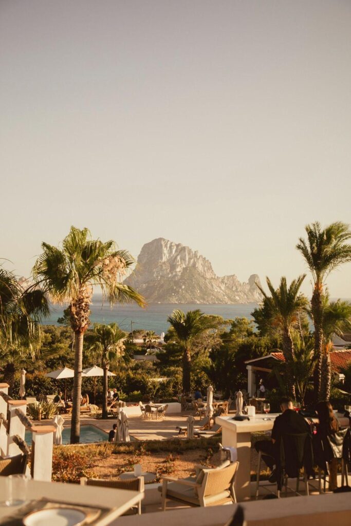 Scenic view of the island of Ibiza with palm trees, mountains, and a calm sea, perfect for relaxation in Mallorca